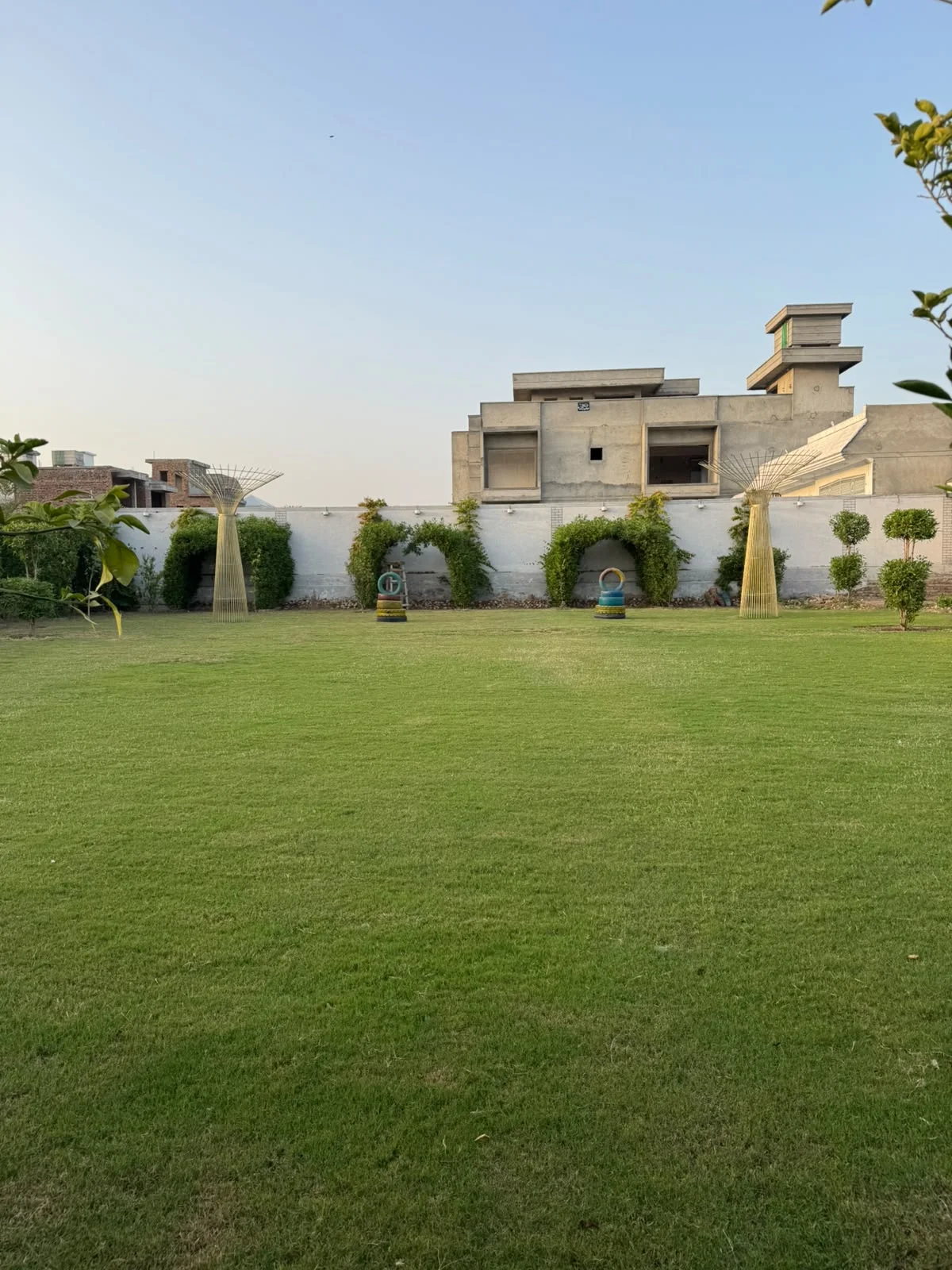 Green lawn and garden arches at Imperial Farmhouse in Rahim Yar Khan